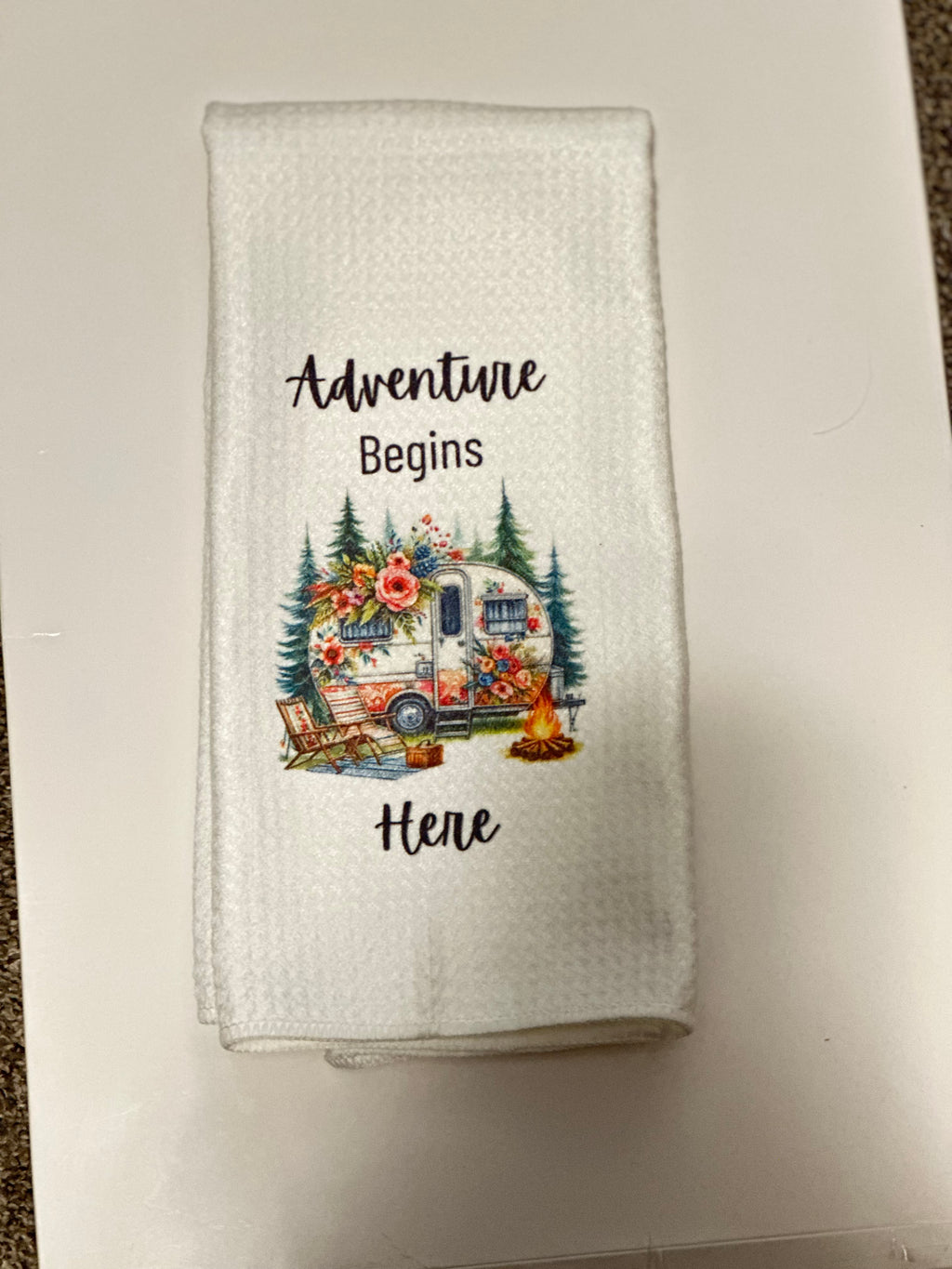 Vintage camper kitchen towel with pine trees, flowers, and campfire design — adventure-themed home décor